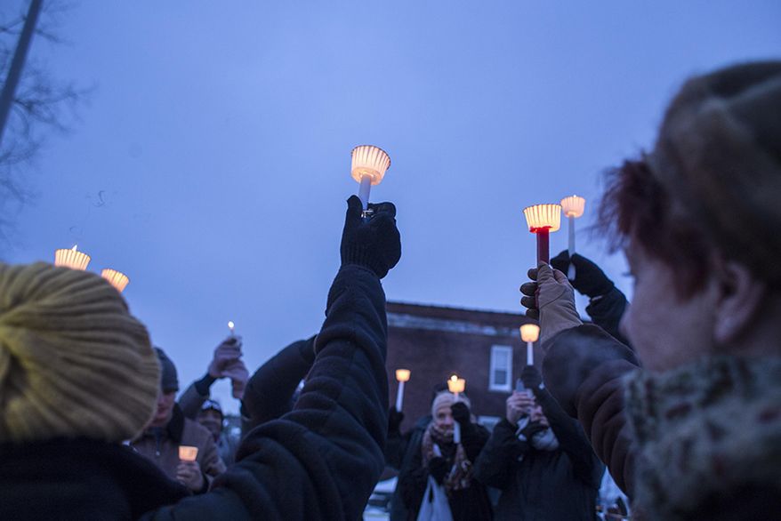 Attendees raise their candles during a vigil at the site of the latest fire at the Heidelberg Project in Detroit, Thursday, March 13, 2014. A March 7 fire destroyed a house covered in stuffed animals and dolls that was part of the Heidelberg Project. It was the latest casualty in a 10-month string of suspicious fires at houses that are part of the interactive outdoor art installation. Tyree Guyton founded the Heidelberg Project on Detroit's east side in 1986 as a response to urban decay. (AP Photo/The Saginaw News, Katie Bailey) ALL LOCAL TV OUT; LOCAL TV INTERNET OUT