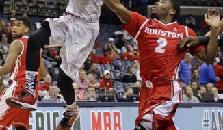 Louisville guard Russ Smith, left, lays the ball up ahead of Houston guard Brandon Morris, right, during the first half of an NCAA college basketball game in the semifinals of the American Athletic Conference men&#39;s tournament Friday, March 14, 2014, in Memphis, Tenn. (AP Photo/Mark Humphrey)