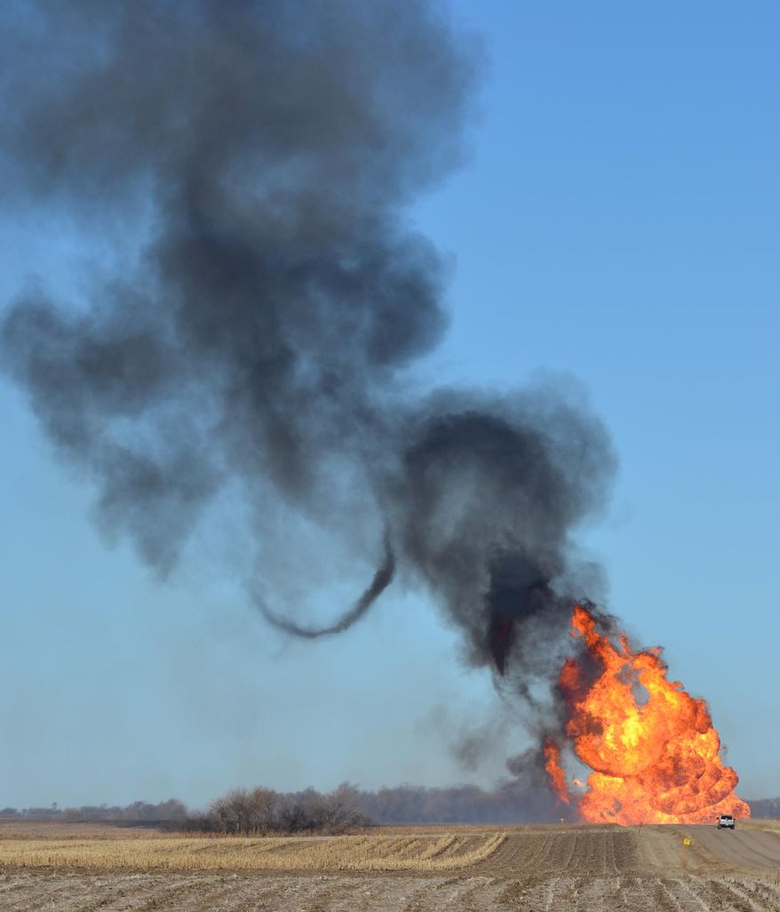 Flames leap into the air from a natural gas pipeline fire on Friday, March 14, 2014 north of Fremont. The line erupted about 8:30 a.m. Friday near the intersection of county roads 20 and O, about six miles north of Fremont. No damage to any structures has been reported. Firefighters from four departments were waiting nearby for workers to turn off the gas flow. The flames towered dozens of feet into the sky, and the heat kept firefighters from getting close enough to see what caused the blast. (AP Photo/The Tribune, Tracy Buffington )