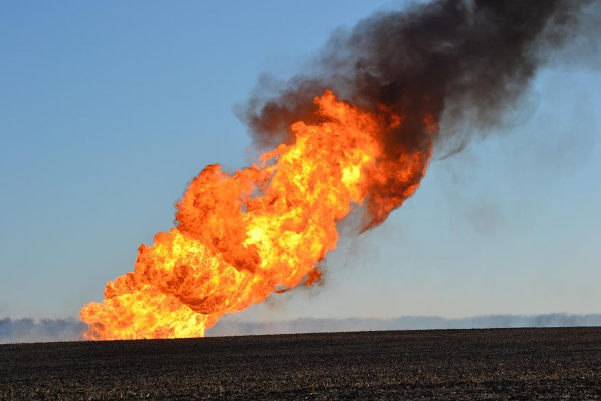 Flames leap into the air from a natural gas pipeline fire on Friday, March 14, 2014 north of Fremont. The line erupted about 8:30 a.m. Friday near the intersection of county roads 20 and O, about six miles north of Fremont. No damage to any structures has been reported. Firefighters from four departments were waiting nearby for workers to turn off the gas flow. The flames towered dozens of feet into the sky, and the heat kept firefighters from getting close enough to see what caused the blast. (AP Photo/The Tribune, Chris Zavadil)
