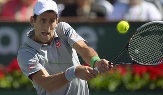 Novak Djokovic, of Serbia, hits to Julien Benneteau, of France, in their quarterfinal match at the BNP Paribas Open tennis tournament on Friday, March 14, 2014, in Indian Wells, Calif. (AP Photo/Mark J. Terrill)