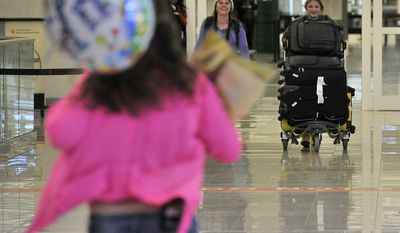 Karina Bundy, foreground, of Montgomery, Ala., runs to greet her mother, Lisa, and sister, Nastia, background right, Friday, March 14, 2014, at Hartsfield Jackson Atlanta International Airport, in Atlanta. Lisa and Nastia returned from Ukraine after finalizing Nastia&#x27;s adoption there. (AP Photo/AL.com, Julie Bennett)