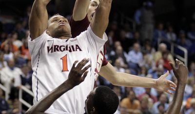 Virginia&#x27;s Justin Anderson, center, shoots between Florida State&#x27;s Okaro White, front, and Boris Bojanovsky, back, during the second half of an NCAA college basketball game in the quarterfinal round of the Atlantic Coast Conference tournament in Greensboro, N.C., Friday, March 14, 2014. (AP Photo/Bob Leverone)