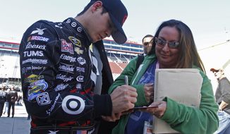 Driver Kyle Larson (42) signs an autograph after qualifying for the NASCAR Nationwide series auto race at Bristol Motor Speedway on Saturday, March 15, 2014, in Bristol, Tenn. Larson will start from the pole position. (AP Photo/Wade Payne)