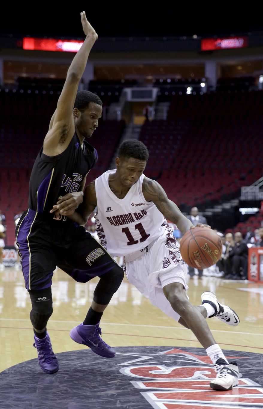 Alabama A&M's Arthur Capers (11) drives toward the basket as Prairie View A&M's Montrael Scott defends during the first half of an NCCA college basketball game in the semifinals of the Southwestern Athletic Conference tournament Friday, March 14, 2014, in Houston.