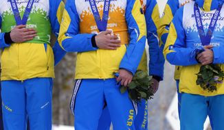 Ukraine&#x27;s athletes cover their silver medals with hands after finishing second in cross country 4x2.5km open relay at the 2014 Winter Paralympic, Saturday, March 15, 2014, in Krasnaya Polyana, Russia. The majority of Ukraine&#x27;s Paralympic medalists covered their medals during medal ceremonies. (AP Photo/Dmitry Lovetsky)