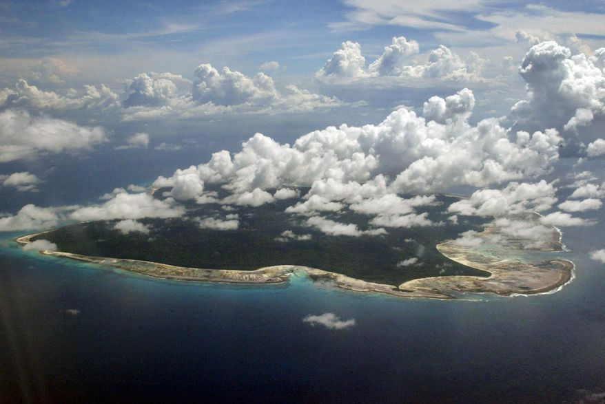 In this Nov. 14, 2005, file photo, clouds hang over the North Sentinel Island, in India's southeastern Andaman and Nicobar Islands. India used heat sensors on flights over hundreds of uninhabited Andaman Sea islands Friday, March 14, 2014, and will expand its search for the missing Malaysia Airlines jet farther west into the Bay of Bengal, officials said. The Indian-controlled archipelago that stretches south of Myanmar contains 572 islands covering an area of 720-by-52 kilometers. Only 37 are inhabited, with the rest covered in dense forests. (AP Photo/Gautam Singh, File)