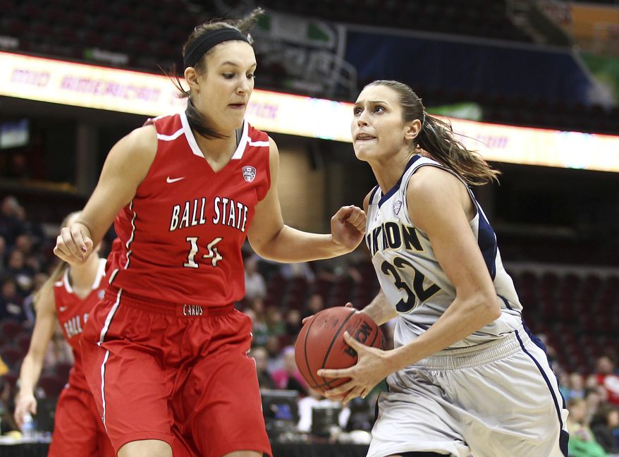 Akron's Rachel Tecca, right, eyes the basket as she drives against Ball State's Renee Bennett during the first half of an NCAA college basketball game in the championship of the Mid-American Conference tournament Saturday, March 15, 2014, in Cleveland. (AP Photo/Aaron Josefczyk)