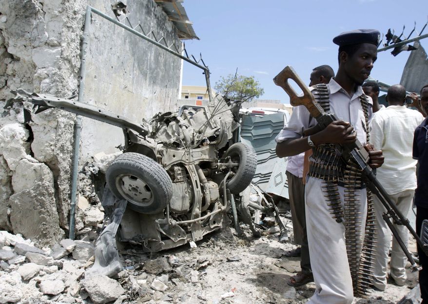 A Somali soldier walks near the wreckage of a car bomb that went off near the gate of one of Mogadishu's most popular hotels. Saturday, March, 15, 2014, A Somali police officer says a suicide car bomber accidentally detonated his explosives near a popular hotel in the Somali capital. Capt. Mohamed Hussein said the bomber appeared to have prematurely detonated his explosives-laden car Saturday as he tried to park near a hotel. No others were hurt or killed in the blast. (AP Photo/Farah Abdi Warsameh)