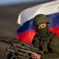 A pro-Russian soldier is back dropped by Russia flag while manning a machine-gun outside an Ukrainian military base in Perevalne, Ukraine, Saturday, March 15, 2014. Tensions are high in the Black Sea peninsula of Crimea, where a referendum is to be held Sunday on whether to split off from Ukraine and seek annexation by Russia. (AP Photo/Vadim Ghirda)