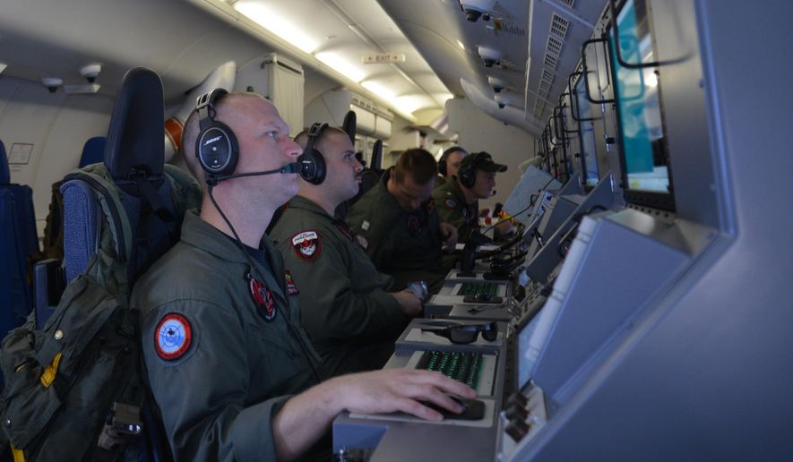 In this photo provided by the U.S. Navy, crew members on board an aircraft P-8A Poseidon assist in search and rescue operations for Malaysia Airlines flight MH370 in the Indian Ocean on Sunday, March 16, 2014. Malaysian authorities on Sunday examined a flight simulator that was confiscated from the home of one of the missing jetliner&#39;s pilots. The Boeing 777 went missing less than an hour into a March 8, flight from Kuala Lumpur to Beijing as it entered Vietnamese airspace. (AP Photo/U.S. Navy, Eric A. Pastor)