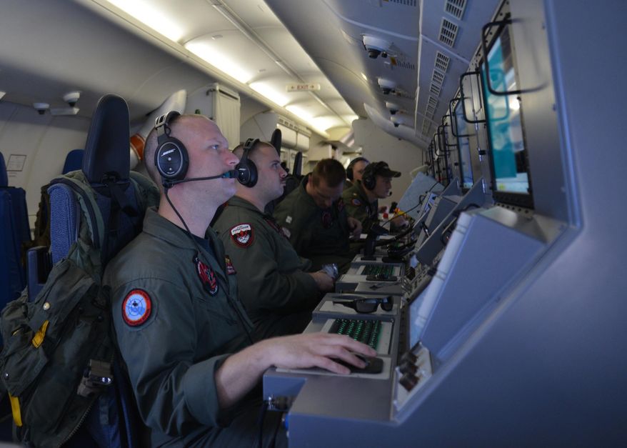 In this photo provided by the U.S. Navy, crew members on board an aircraft P-8A Poseidon assist in search and rescue operations for Malaysia Airlines flight MH370 in the Indian Ocean on Sunday, March 16, 2014. Malaysian authorities on Sunday examined a flight simulator that was confiscated from the home of one of the missing jetliner&#x27;s pilots. The Boeing 777 went missing less than an hour into a March 8, flight from Kuala Lumpur to Beijing as it entered Vietnamese airspace. (AP Photo/U.S. Navy, Eric A. Pastor)