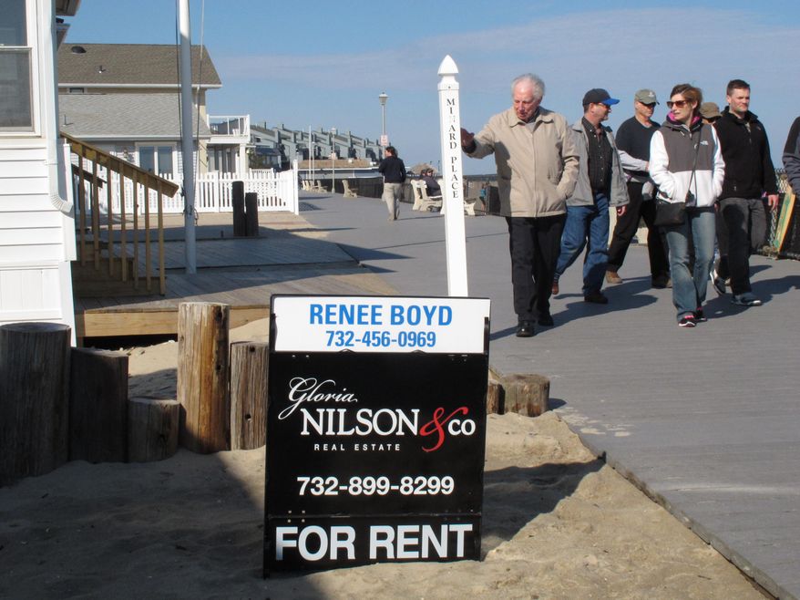 This March 8, 2014 photo shows strollers on the boardwalk in Point Pleasant Beach N.J. walking past a home being offered as a summer rental. The rental market at the Jersey shore is developing later than usual this year in parts of the region, due to a highway reconstruction project, uncertainty about which beaches will be open this summer, and a seemingly unending string of winter storms that have kept people from driving to the shore to check out vacation spots. The shore towns are counting on this summer to be better than last year's as they struggle to recover from the Oct. 2012 storm. (AP Photo/Wayne Parry)