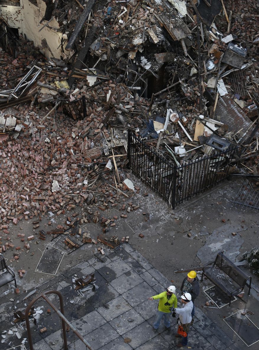 Workers survey an area covered in rubble Friday, March 14, 2014, two days after a natural gas explosion leveled two apartment buildings in New York. Using sound devices to probe for voices and telescopic cameras to peer into small spaces, workers searching a pile of rubble from a gas explosion in the East Harlem section of Manhattan, continued to treat it as a rescue operation, holding onto the possibility of finding survivors from a blast that brought down two apartment buildings and killed at least eight people. (AP Photo/Julio Cortez)