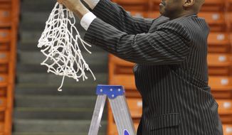 Tulsa head basketball coach Danny Manning makes the final cut on the net after his team&#39;s Conference USA Tournament championship game victory Saturday  March 15, 2014 in El Paso, Texas. (AP Photo/Victor Calzada)