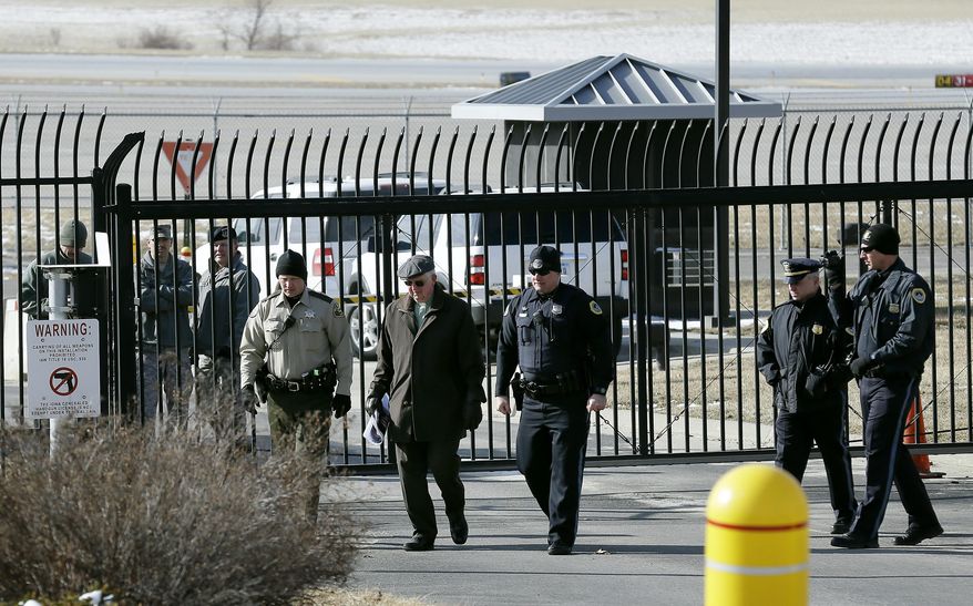 A protester is arrested by law enforcement officers at the Iowa Air National Guard base, Monday, March 17, 2014, in Des Moines, Iowa. Seven protesters, who were rallying against the use of drones to carry out military strikes, were arrested at the base. (AP Photo/Charlie Neibergall)