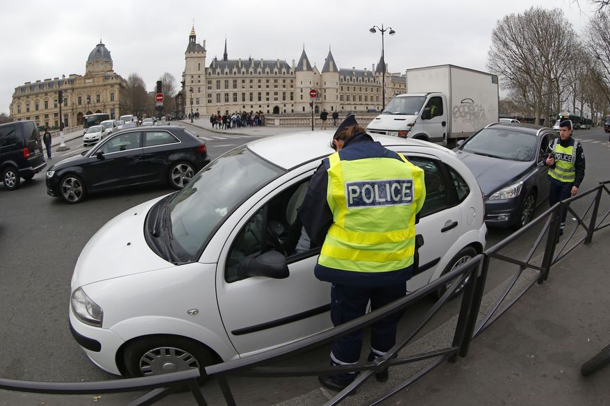 Police officers control a vehicle along the Seine river in Paris, Monday, March 17, 2014. Cars with even-numbered license plates are prohibited from driving in Paris and its suburbs Monday, following a government decision over the weekend. Paris is taking drastic measures to combat its worst air pollution in years, banning around half of the city's cars and trucks from its streets in an attempt to reduce the toxic smog that's shrouded the City of Light for more than a week. (AP Photo/Michel Euler)