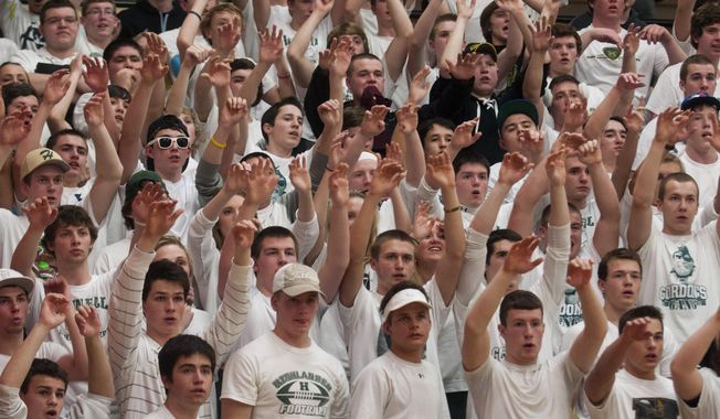 In this March 13, 2014 photo, Howell students put their hands up during a Class A boys&#x27; regional high school basketball final game against Grand Blanc at Linden High School in Linden, Mich. High school officials in Howell said they reprimanded students involved in posting racist messages on Twitter after the school&#x27;s predominantly white basketball team defeated Grand Blanc. (AP Photo/The Flint Journal, Katie McLean) LOCAL TV OUT; LOCAL INTERNET OUT