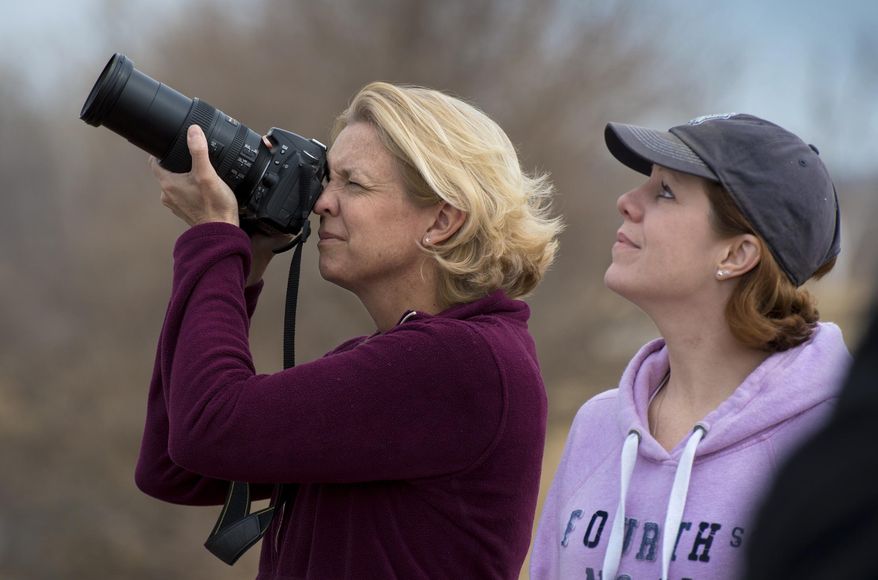 In this March 11, 2014 photo, Michelle McMullen, left, of Liberty and Rene Sonne of Kansas City photograph the snow geese at the Squaw Creek National Wildlife Refuge near Mound City, Mo. More than a million snow geese have been counted at a northwest Missouri refuge in an annual spectacle that pumps much-needed revenue into the area's economy. (AP Photo/The Kansas City Star, Keith Myers)