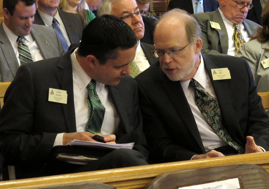 Kansas Hospital Association lobbyists Chad Austin, left, and Tom Bell, right, confer during a Kansas House committee hearing on legislation increasing limits on non-economic damages in lawsuits, Monday, March 17, 2014, at the Statehouse in Topeka, Kan. The association is supporting the bill, which also changes evidence rules. (AP Photo/John Hanna)