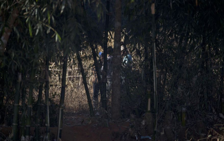 In this Jan 28, 2014 photo, a woman, identified by the villagers as a drug dealer, retails heroin and opium for addicts in Nampatka village, northeastern Shan State, Myanmar. Dealers hanging out at the graveyard, on street corners and behind hillside homes pay security forces to leave them alone, a senior village official said, speaking on condition of anonymity because he feared reprisals. The drug trade - and addiction - is running wild along the jagged frontier. In this village, roughly half the population uses heroin and opium. (AP Photo/Gemunu Amarasinghe)
