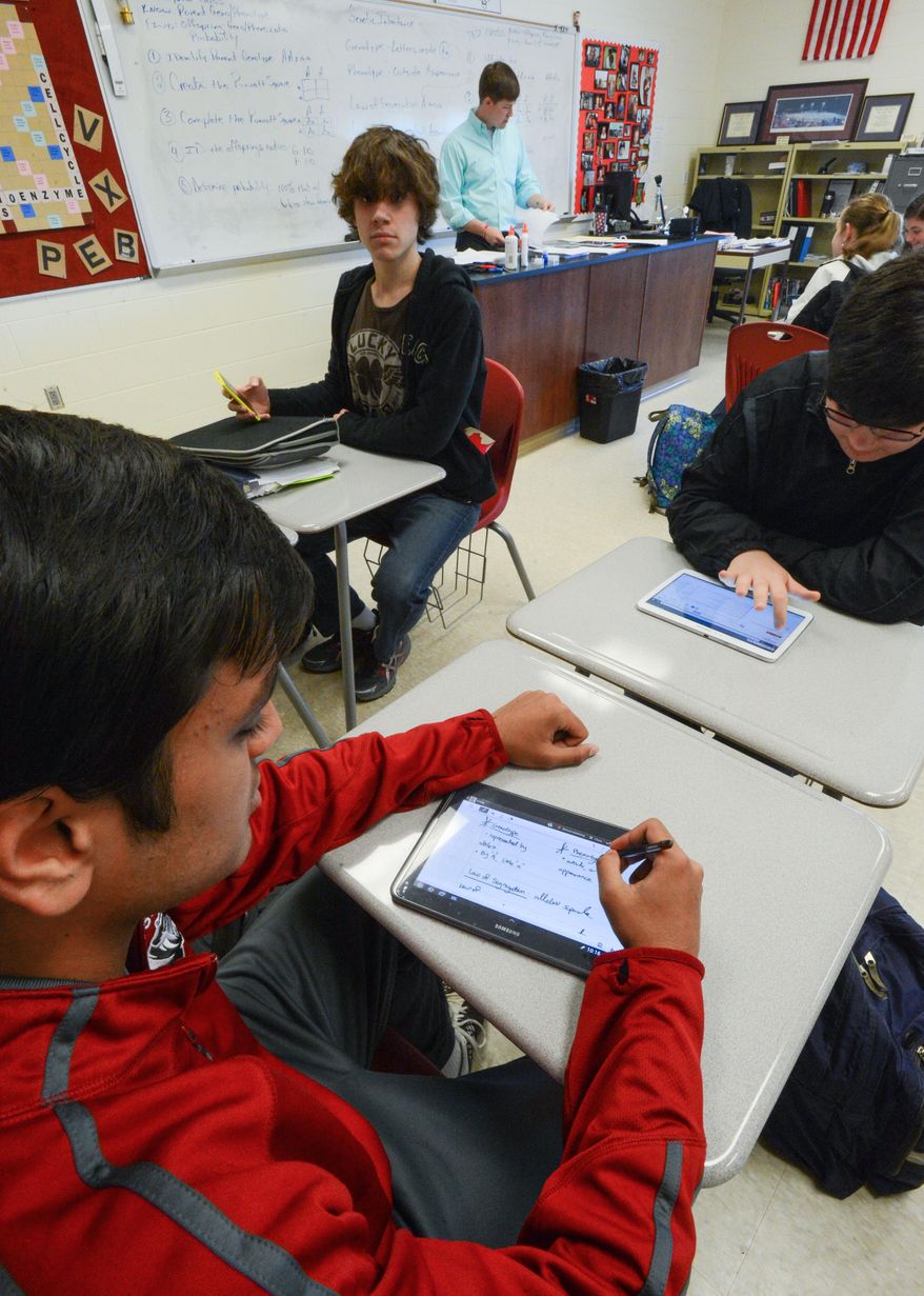 Students at Hartselle High School in Hartselle, Ala., use personal technology devices like cell phones and tablets for social media and academics. Jainik Patel uses a tablet with a stylus to take notes in Biology class, March 13, 2014. (AP Photo/The Decatur Daily, Gary Cosby Jr.)