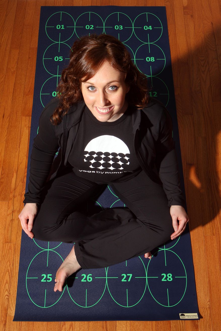 In this March 7, 2014 photo, Elizabeth Morrow poses on her specially designed Yoga by Numbers mat in Bow, N.H. The mat gives true yoga beginners a step-by-step roadmap to learn poses at their own pace. (AP Photo/Jim Cole)