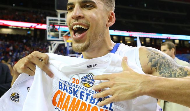 Florida guard Scottie Wilbekin grabs his championship shirt after defeating Kentucky in an NCAA college basketball game for the Southeastern Conference tournament, Sunday, March 16, 2014, in Atlanta. Florida won 61-60. (AP Photo/Atlanta Journal-Constitution, Curtis Compton)