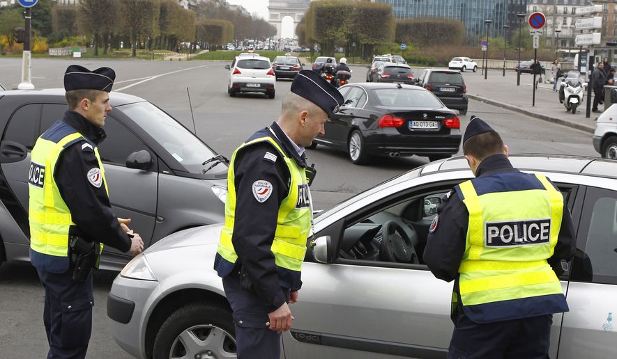 Police officers control a vehicle in Paris, Monday, March 17, 2014. Cars with even-numbered license plates are prohibited from driving in Paris and its suburbs Monday, following a government decision over the weekend.  Paris is taking drastic measures to combat its worst air pollution in years, banning around half of the city&#39;s cars and trucks from its streets in an attempt to reduce the toxic smog that&#39;s shrouded the City of Light for more than a week. Visible in background is the Arc de Triomphe.(AP Photo/Remy de la Mauviniere)