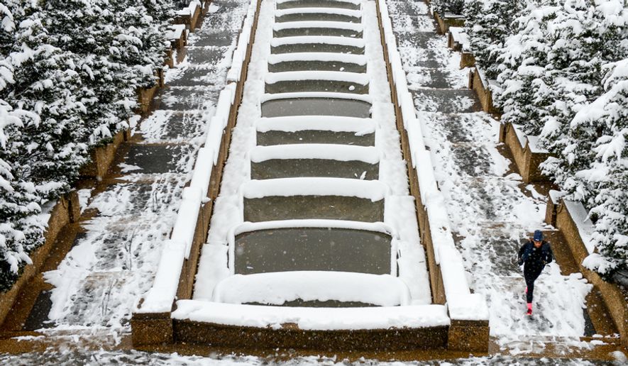 Melissa Almanzar of Washington, D.C. jogs through Meridian Hill Park as the region gets another snow storm, Washington, D.C., Monday, March 17, 2014. (Andrew Harnik/The Washington Times)
