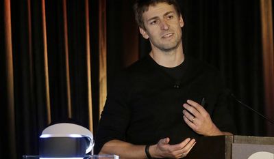 Richard Marks, senior director of research and development at Sony Computer Entertainment America, speaks about the PlayStation 4 virtual reality headset Project Morpheus, pictured at left, at the Game Developers Conference 2014 in San Francisco, Tuesday, March 18, 2014.  (AP Photo/Jeff Chiu)