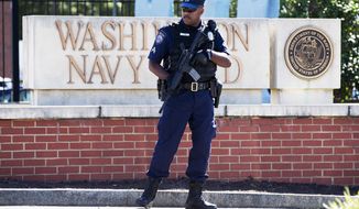 FILE - This Sept. 17, 2013 file photo shows an armed officer who said he is with the Defense Department, standing near guard the gate at the Washington Navy Yard the day after a gunman launched an attack inside the Yard. An independent review triggered by the Washington Navy Yard killings last year says threats to Defense Department personnel and facilities increasingly are coming from within. It says the department must rethink its outdated security theory that suggests defending the perimeters can keep threats away. Instead, it says that terrorism, espionage and even physical threats are coming from trusted insiders. (AP Photo/Jacquelyn Martin, File)