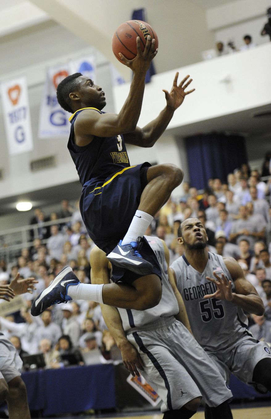 West Virginia guard Juwan Staten (3) goes to the basket against Georgetown guard Jabril Trawick (55) during the first half of an NCAA college NIT tournament first round basketball game, Tuesday, March 18, 2014, in Washington. (AP Photo/Nick Wass)