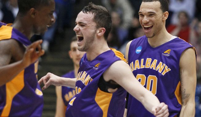 Albany guard Peter Hooley, center, celebrates with guard D.J. Evans, left, and forward Gary Johnson after Albany defeated Mount St. Mary&#x27;s 71-64 in a first-round game of the NCAA college basketball tournament, Tuesday, March 18, 2014, in Dayton, Ohio. (AP Photo/Skip Peterson)