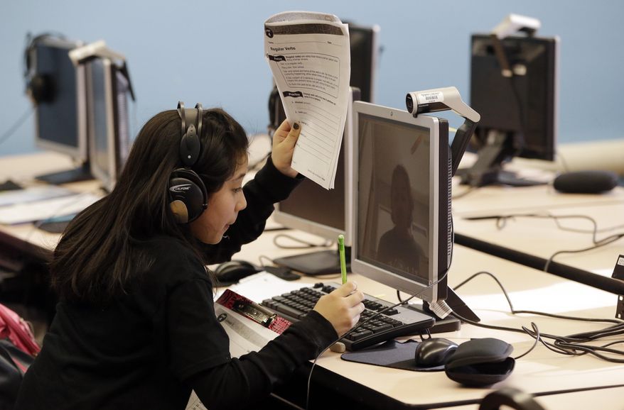 ADVANCE FOR USE SUNDAY, MARCH 23, 2014 AND THEREAFTER - In this Feb. 26, 2014 photo, Bennett Elementary student Marisol Tapia De Arcos works with a student from Novi High School via Skype during a tutoring session in Detroit. The public school in Southwest Detroit helps students with one-on-one tutoring in the 4th and 5th grades via Skype with student volunteers at a suburban high school. (AP Photo/Carlos Osorio)