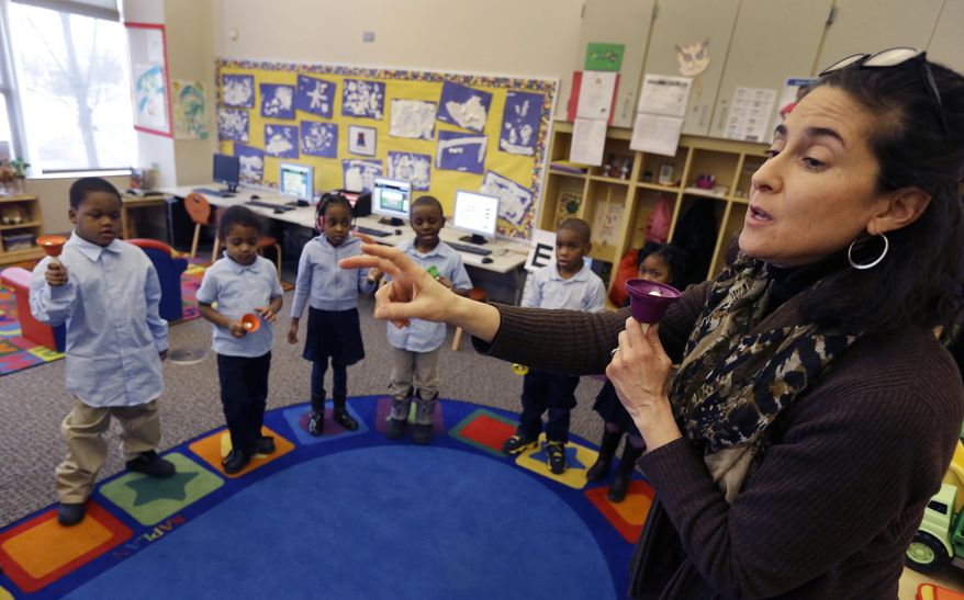 ADVANCE FOR USE SUNDAY, MARCH 23, 2014 AND THEREAFTER - In this Feb. 25, 2014 photo, Golightly Education Center teacher Amy Andersen-Prebo leads her class in a hand bell song in Detroit. After years without comprehensive sports and arts/music programs, those are now being restored at all DPS elementary and middle schools, thanks in part to foundation grants. (AP Photo/Carlos Osorio)