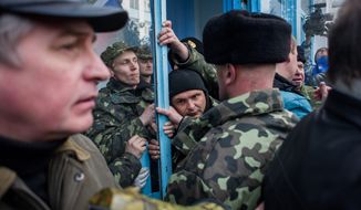 Ukrainian servicemen struggle to defend the navy headquarters in Crimea. Story, A10. (Associated Press)