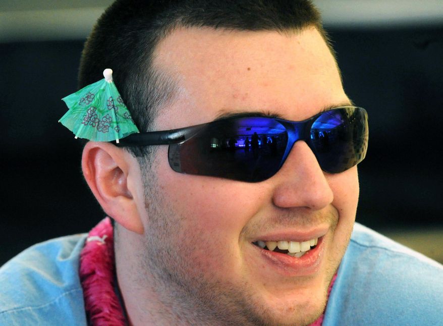 In this Tuesday, March 18, 2014 photo, Northampton Community College studnet Kyle Stout sports a paper umbrella and sunglasses at the Bethlehem, Pa. school. Students are protesting the cancellation of spring break by wearing flip-flops, bathing suits and tank tops to class. (AP Photo/The Express-Times, Sue Beyer)