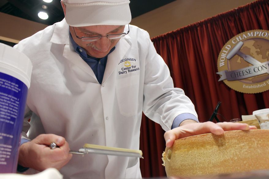 Contest judge John Jaeggi pulls out a plug of cheese that is in the category of smear ripened semi-soft cheese during the first day of judging for 2014 World Championship Cheese Contest, Tuesday, March 18, 2014 in Madison, Wis. Entries in the 2014 World Championship Cheese Contest reached a new record this year, growing five percent to more than 2,600 entries from 22 nations around the world. (AP Photo/Carrie Antlfinger)