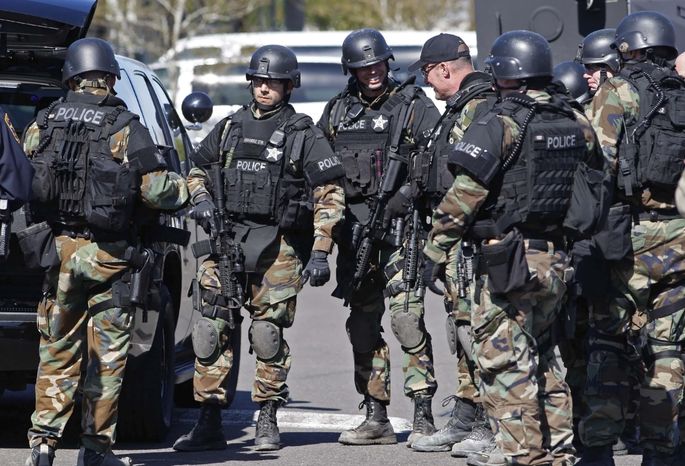 Swat team personnel gather for a briefing before entering the the former Roth&#x27;s grocery store to investigate an armed robbery at School House Square in Keizer, Ore., on Tuesday, March 18, 2014.  A Brinks employee was robbed at gunpoint when he was servicing an ATM machine, said Keizer Police Deputy Chief Jeff Kuhns. (AP Photo/Statesman-Journal, Timothy J. Gonzalez)