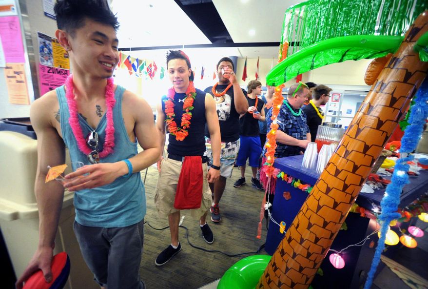 In this Tuesday, March 18, 2014 photo, students at Northampton Community College walk past an island drink station set up by general manager of dining services, Bob Meyer, at the Bethlehem, Pa. school. The students are protesting the cancellation of spring break by wearing flip-flops, bathing suits and tank tops to class. (AP Photo/The Express-Times, Sue Beyer)