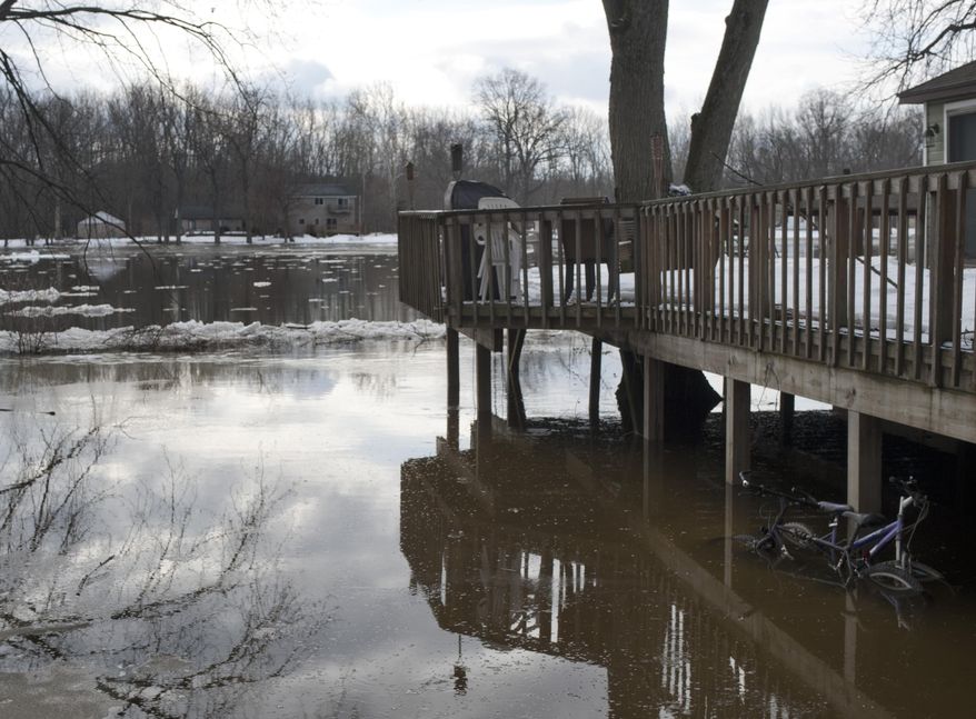 The rising Grand River approaches homes on Abrigador Trail in Comstock Park, Mich. Thursday, March 20, 2014. A flood watch is in effect for the Grand River around Grand Rapids due to ice jams along the waterway. The National Weather Service reports jams are confirmed in at least two areas, with chunks of ice about 8 inches thick in places. (AP Photo/The Grand Rapids Press, Chris Clark) ALL LOCAL TV OUT; LOCAL TV INTERNET OUT