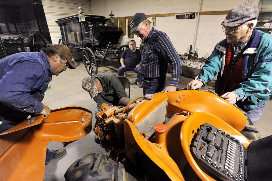 ADVANCE FOR USE MONDAY, MARCH 24, 2014, AND THEREAFTER- In this March 17, 2014 photo, members of the Friends of Gus Pruser Agriculture Exhibit take apart an Allis Chalmers G tractor at the Gus Pruser Agriculture Exhibit at the Z.I. Hale Museum. in Winters, Texas. (AP Photo/The Abilene Reporter-News, Ronald W. Erdrich)