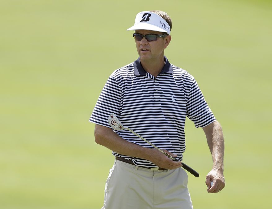 Davis Love III talks to his caddie as he surveys the first green during a practice round before the start of the Arnold Palmer Invitational golf tournament at Bay Hill Wednesday, March 19, 2014, in Orlando, Fla. (AP Photo/Chris O'Meara)