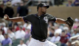 Colorado Rockies starting pitcher Juan Nicasio throws to the Milwaukee Brewers during the first inning of a spring exhibition baseball game in Scottsdale, Ariz., Thursday, March 20, 2014. (AP Photo/Chris Carlson)