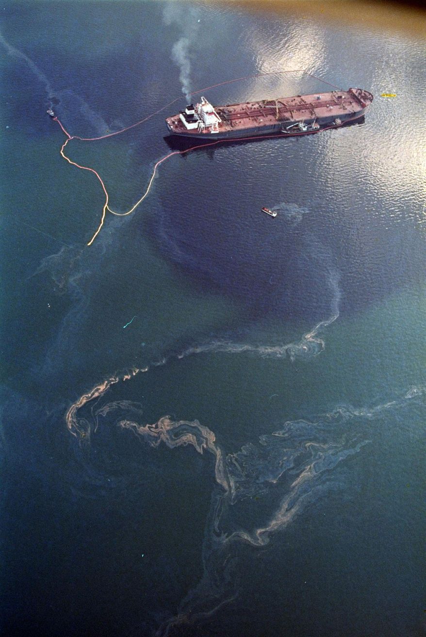 FILE - In this April 9, 1989 file photo, crude oil from the tanker Exxon Valdez, top, swirls on the surface of Alaska's Prince William Sound near Naked Island. The 987-foot tanker, carrying 53 million gallons of crude, struck Bligh Reef at 12:04 a.m. on March 24, 1989, and within hours unleashed an estimated 10.8 million gallons of thick, toxic crude oil into the water. Storms and currents then smeared it over 1,300 miles of shoreline. Twenty five years later, the region, its people and its wildfire are still recovering. (AP Photo/John Gaps III, File)