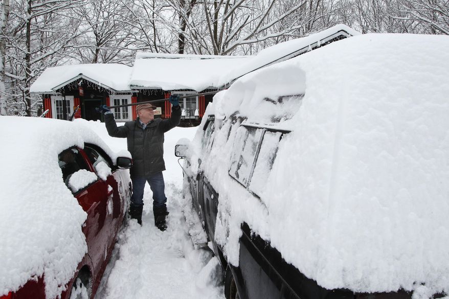 Donald Croteau works to clear nearly a foot of snow off his car on the first day of spring, Thursday, March 20, 2014 in North Woodstock, N.H. Much of the country remains in a deep freeze, delaying the risk of spring flooding into April in the upper Midwest to New England. While major flooding is not expected, experts say there's a moderate risk of flooding in the southern Great Lakes region because of above-average snowpack. (AP Photo/Jim Cole)