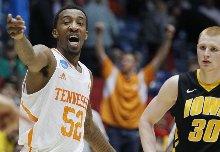 Tennessee guard Jordan McRae (52) motions to a teammate while Iowa forward Aaron White (30) watches in overtime of a first-round game of the NCAA college basketball tournament, Wednesday, March 19, 2014, in Dayton, Ohio. McRae led Tennessee to a 78-65 win with 20 points. (AP Photo/Skip Peterson)