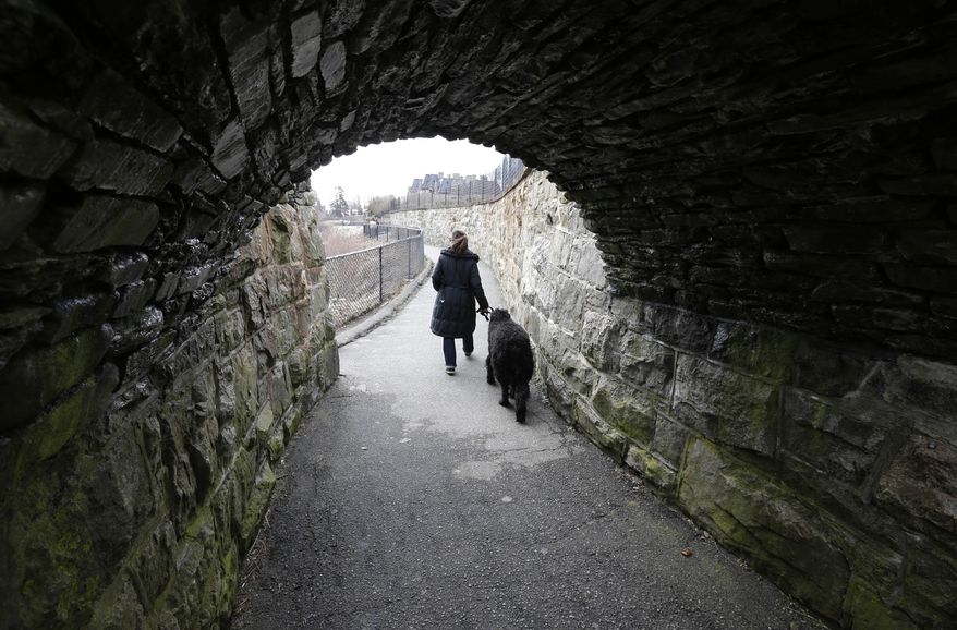 Tayla Burns, of Newport, R.I., walks her five-year-old Bouvier "Lenny" on the Cliff Walk walkway along the Atlantic coast on the first day of spring Thursday, March 20, 2014, in Newport. As much of the United States remained in a deep freeze, government forecasters Thursday predicted temperatures will be below normal this spring across the northern U.S. (AP Photo/Steven Senne)