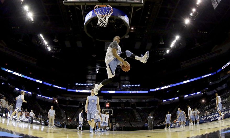 North Carolina's Marcus Paige moves the ball between his legs as he attempts a dunk during practice for the NCAA college basketball tournament in San Antonio, Thursday, March 20, 2014. North Carolina plays Providence in a second-round game on Friday. (AP Photo/David J. Phillip)
